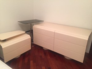 comò e comodino di camera bianca completa